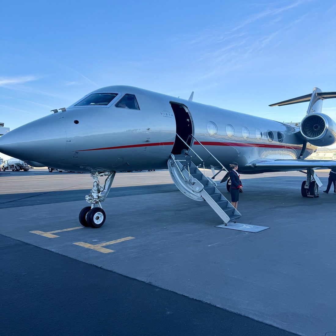 A Gulfstream with its airstair open under a clear blue sky