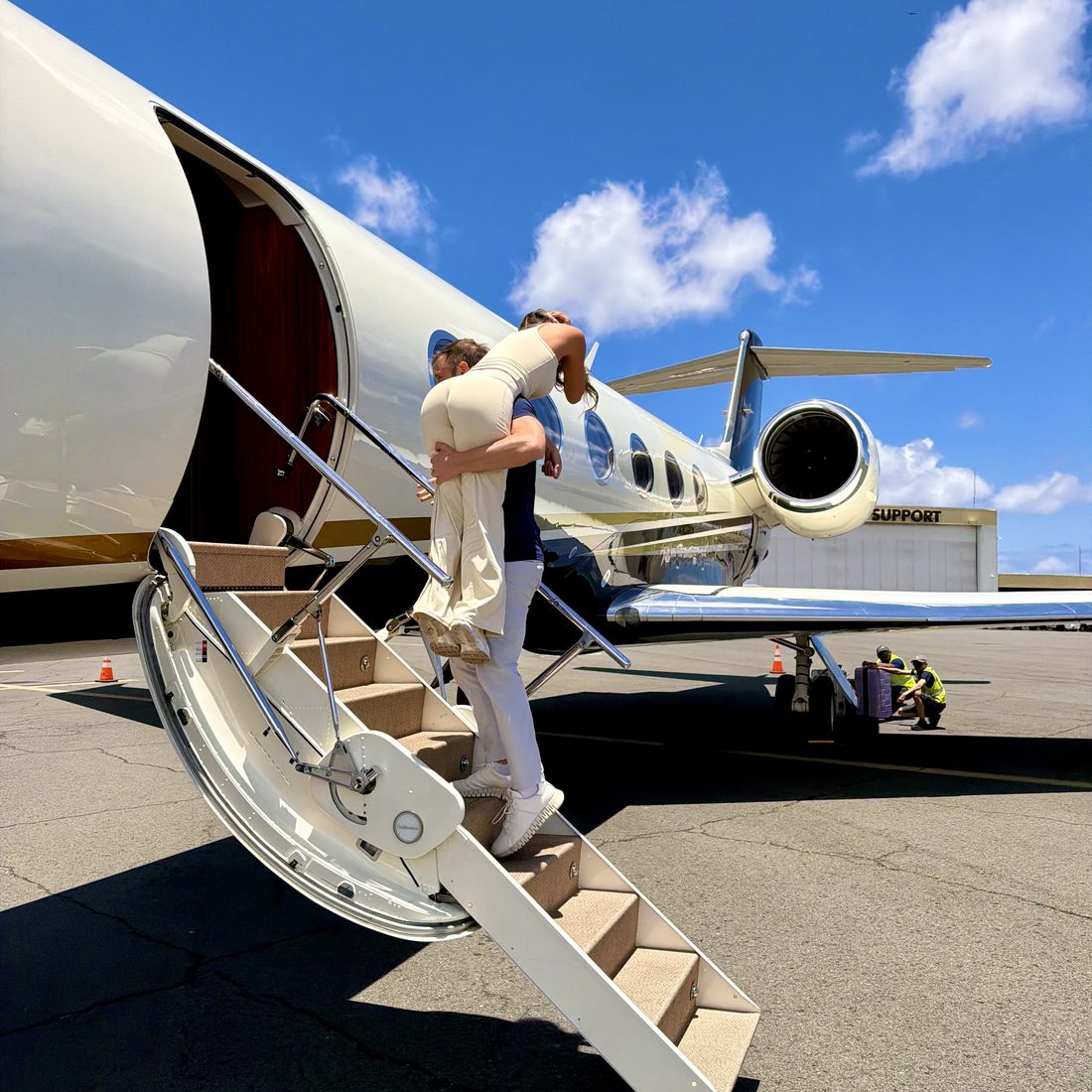 Boarding a private jet by airstair on a bright island day