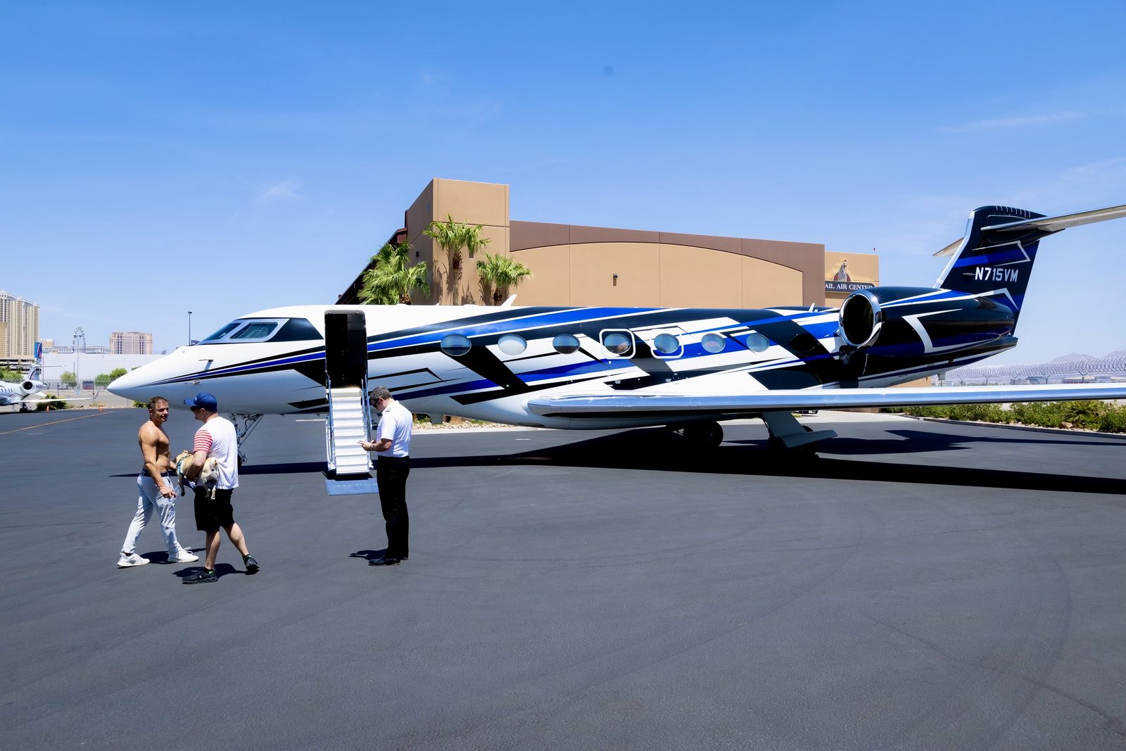A black and blue Gulfstream jet on the tarmac with its stairs down